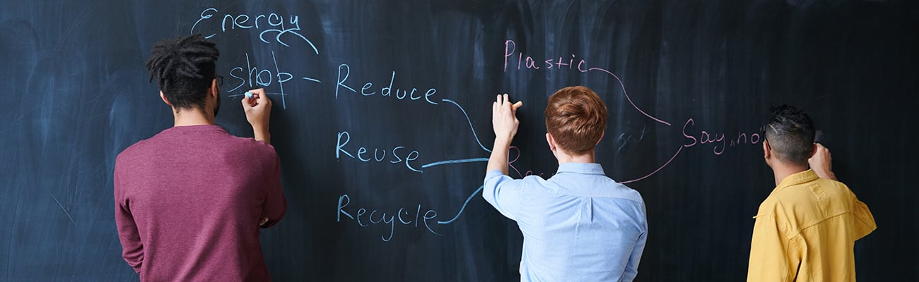 students writing on chalkboard