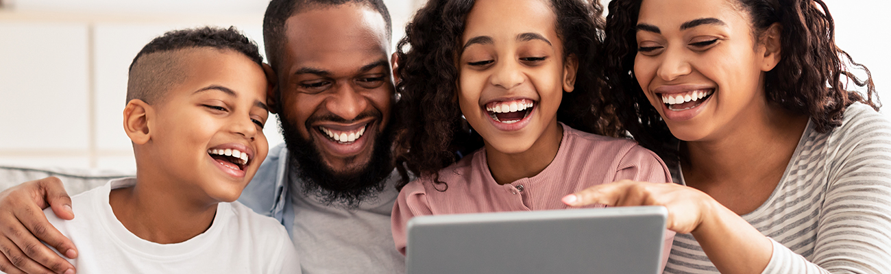 parents-adults-kids-family-in-group-looking-at-tablet-smiling